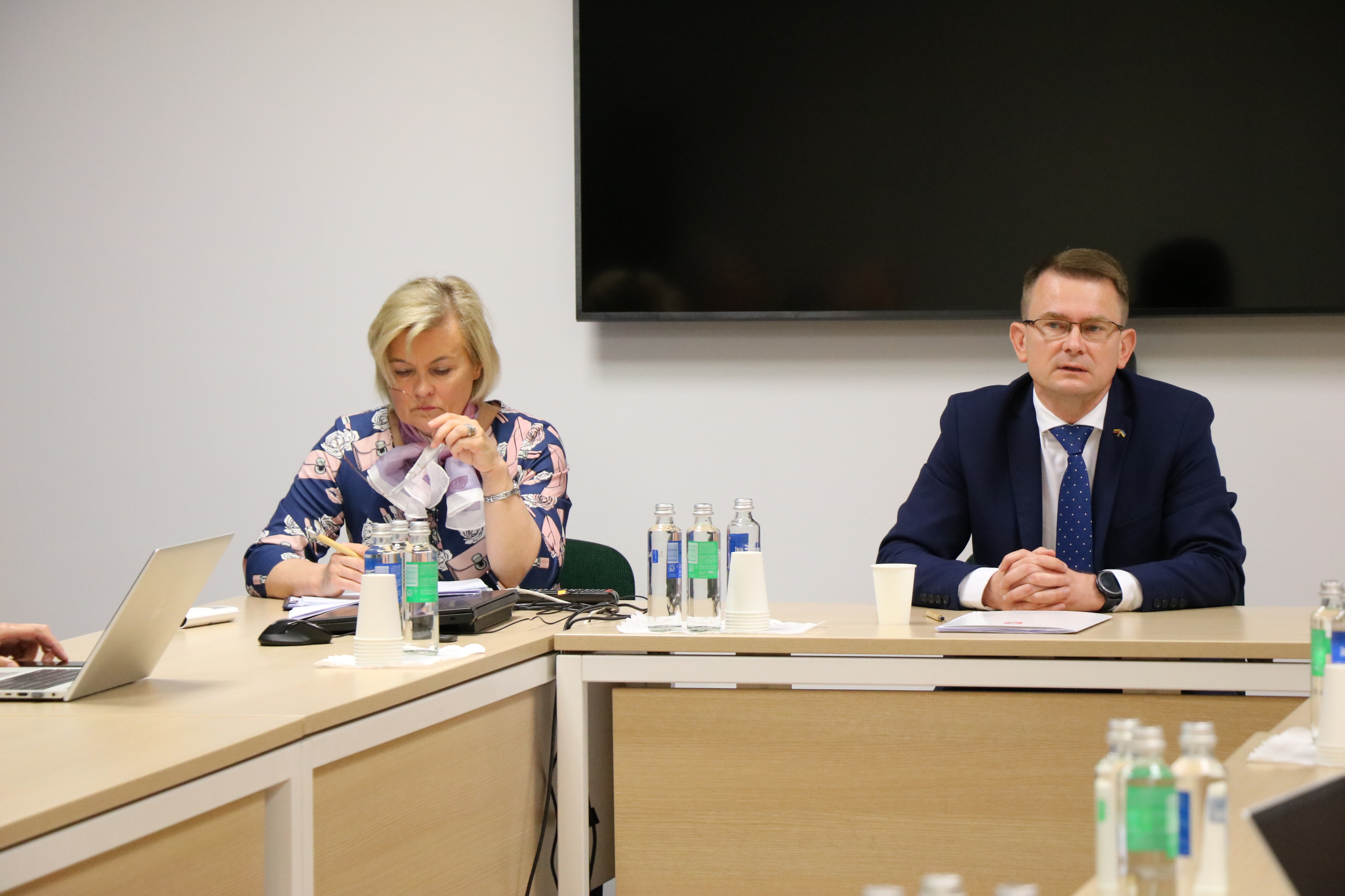 Sveikatos apsaugos ministras A. Dulkys su patarėja sėdi prie stalo